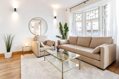 ein Wohnzimmer mit einem Sofa und einem Spiegel in der Unterkunft Luminous Luxe - White and Gold in Luxemburg (Stadt)
