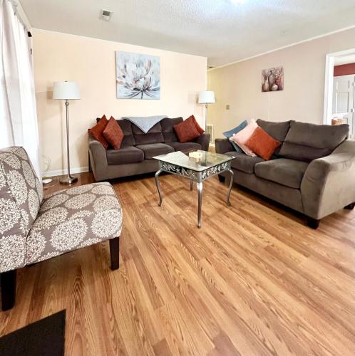 a living room with two couches and a table at A Cozy Spot on Montague in Charleston