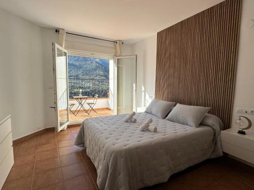 1 dormitorio con cama grande y ventana grande en Casa a la Vera de la Sierra, en Güéjar-Sierra
