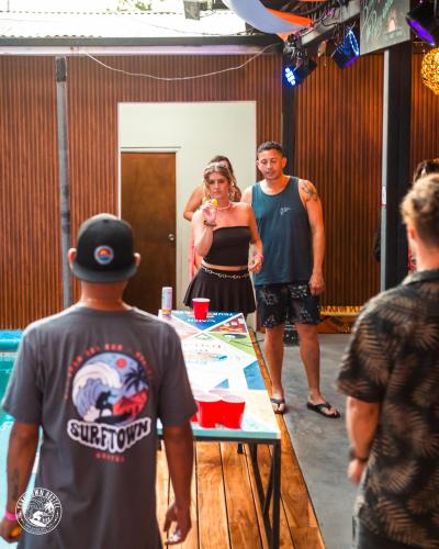 a group of people standing around a table at Surf Town Hostel in San Juan del Sur