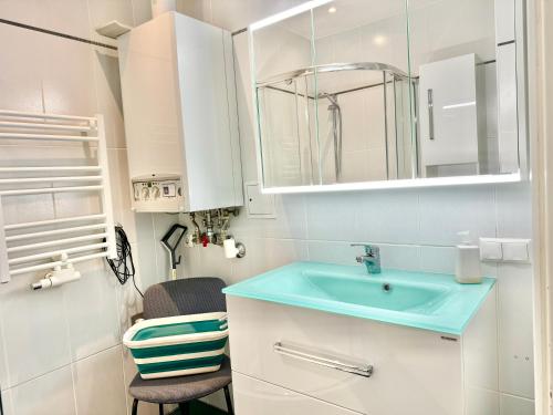 La salle de bains est pourvue d'un lavabo bleu et d'une chaise. dans l'établissement 60 m2 Premium Apartment near Airport - Free Parking, à Schwechat