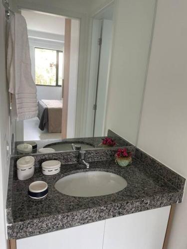 Ondina e Beira Mar في سلفادور: منضدة الحمام مع الحوض والمرآة