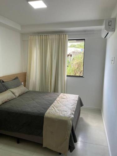 um quarto com uma cama e uma janela em Ondina e Beira Mar em Salvador