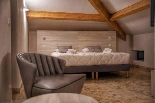 - une chambre avec un grand lit et une chaise dans l'établissement A PIANARELLA, à San-Gavino-di-Carbini