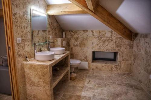 uma casa de banho com um lavatório, um WC e uma televisão em A PIANARELLA em San-Gavino-di-Carbini