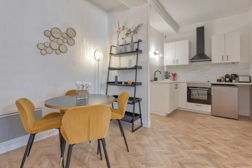 une cuisine et une salle à manger avec une table et des chaises dans l'établissement Superbe pour 4P proche Arc de Triomphe, à Paris