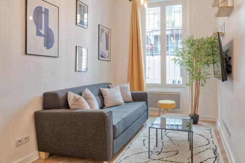 un salon avec un canapé bleu et une table dans l'établissement Superbe pour 4P proche Arc de Triomphe, à Paris