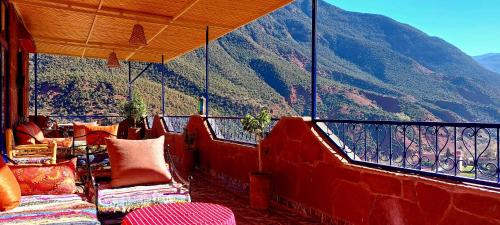 a balcony with chairs and a view of a mountain at DAR EL HACHIMI EL IDRISSI in Ourika