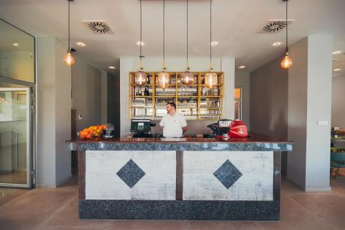 a man standing behind a counter in a kitchen at Wellness Spa Hotel Jola in Banja Luka