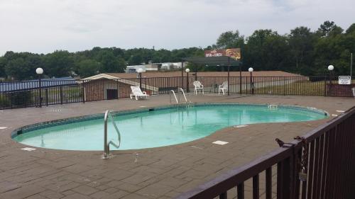 a small swimming pool in a patio with a fence at Red Carpet Inn in Hot Springs