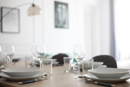 une table en bois avec des assiettes et des verres dans l'établissement Superbe appartement Champs Elysées - 6P, à Paris