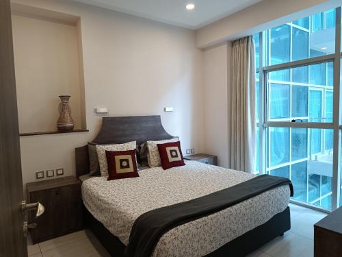 a bedroom with a bed and a large window at Skynest Residences by Lisa's Paradise C in Nairobi