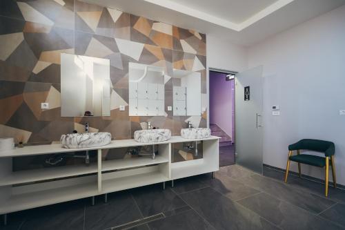 a bathroom with three sinks and a mirror at Wellness Spa Hotel Jola in Banja Luka