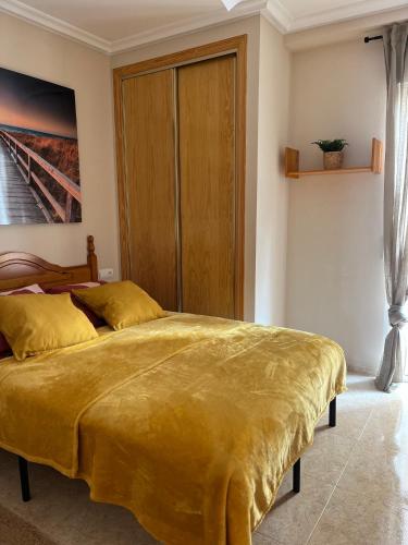a bedroom with a large bed with a yellow blanket at Sol de mar, La Mata (Hiszpania) in La Mata