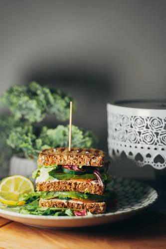 a sandwich on a plate next to a cup of coffee at Wellness Spa Hotel Jola in Banja Luka
