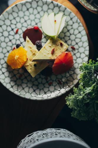 a plate of cheese and fruit on a table at Wellness Spa Hotel Jola in Banja Luka