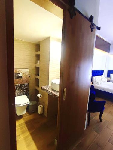 Un baño con inodoro, lavabo y cama. en Deluxe Apartment, en Korinthos