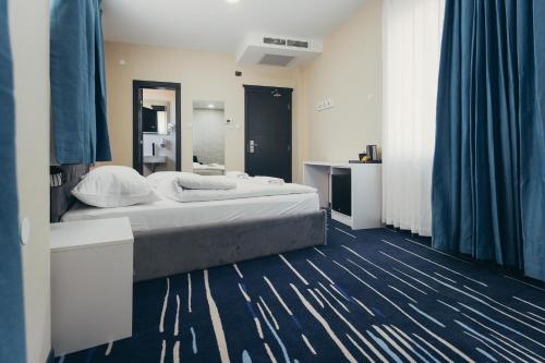 a bedroom with a large bed and a mirror at Wellness Spa Hotel Jola in Banja Luka