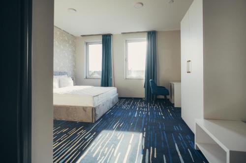 a bedroom with a bed and a desk and window at Wellness Spa Hotel Jola in Banja Luka