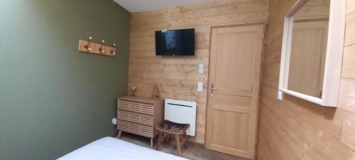 a bedroom with a bed and a television on a wall at Au P'tit Versailles in Châtillon-sur-Seine