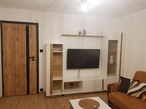 a living room with a flat screen tv on a wall at Apartament Chrobry in Kętrzyn
