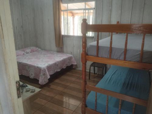 um quarto com um beliche e uma pequena cama em Rancho do Pijuca em Ortigueira