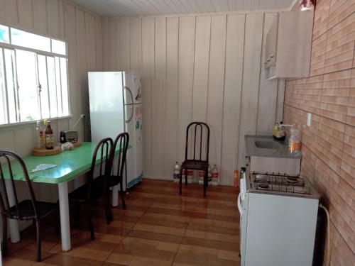 uma cozinha com uma mesa e um frigorífico em Rancho do Pijuca em Ortigueira