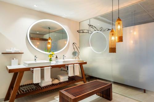 a bathroom with a sink and a mirror at Hyatt Vivid Grand Island in Cancún