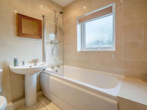 ein Badezimmer mit einem Waschbecken, einer Badewanne und einem Waschbecken in der Unterkunft 2 Bed in Cockermouth 82631 in Cockermouth