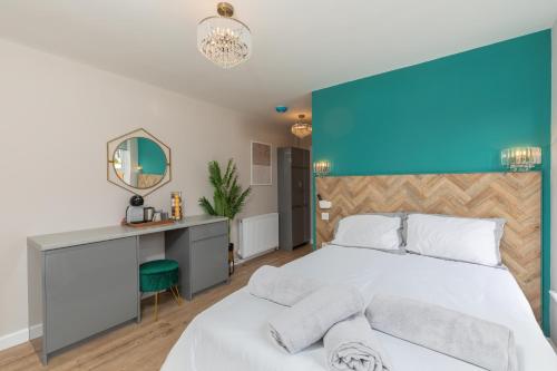 a bedroom with a bed with a blue accent wall at Ocean Studio Apartments in Littlehampton