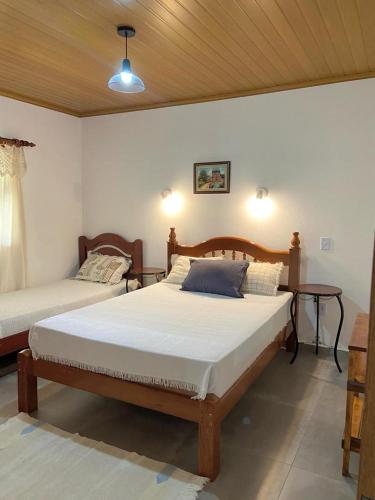 a bedroom with two beds in a room at Condomínio Ypê Casas Maringá MG in Visconde De Maua