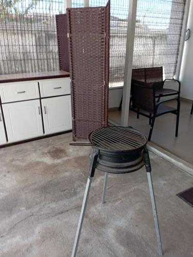 a black chair sitting in a room with a kitchen at Atardeceres Puntarenas in Puntarenas