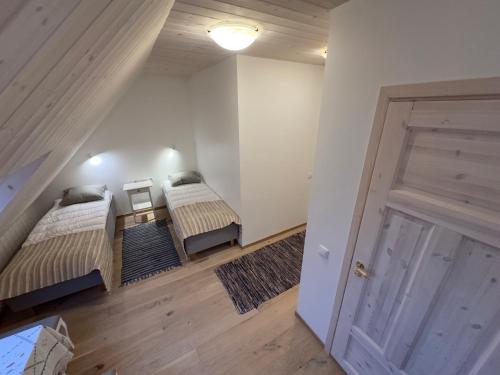 a attic room with two beds and a door at Harmoonikum in Viimsi