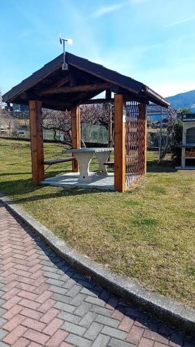 a wooden pavilion with a cross in a park at Casa vacanze Fregè in Castione Andevenno