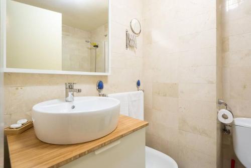 a white bathroom with a sink and a toilet at Cathedral Suites in Málaga