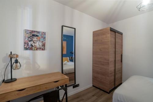 アンティーブにあるCharmant Appartement Antibesのベッドルーム1室(鏡、ベッド1台、ドレッサー付)