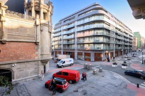 Un camión rojo estacionado frente a un edificio en NUEVO LUJO CENTRO DE BILBAO + WIFI . PARKING, en Bilbao