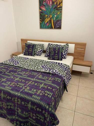 Schlafzimmer mit einem Bett mit blauer und weißer Bettwäsche und Kissen in der Unterkunft Maison Créole en Campagne in Grande Savane