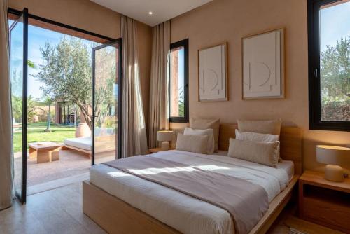 a bedroom with a large bed and a large window at Villa Dar Pampa Marrakech in Marrakesh