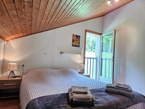 a bedroom with a bed and a large window at Gîte de l'Eau Vive in Saint-Martin-dʼUriage