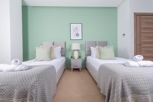 twee bedden in een kamer met wit en groen bij Radieux Appartement à Hydra in Hydra