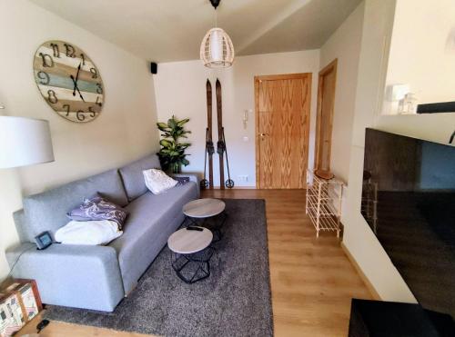 salon z kanapą i zegarem na ścianie w obiekcie Ideal Parejas - Tranquilidad y naturaleza - Vistas al lago w mieście Osséja