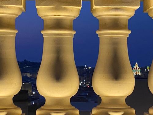 a group of columns with a city in the background at Casa Maria Tereza in Cospicua