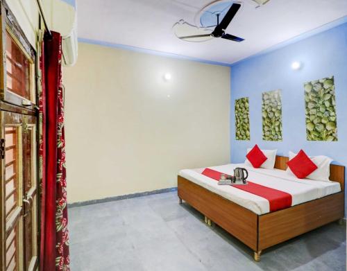 - une chambre avec un lit et des oreillers rouges dans l'établissement OYO Flagship 81042 Hotel Royal Inn, à Manesar