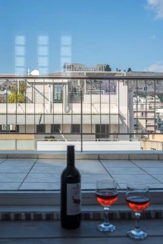 a bottle of wine and two glasses on a table at Parthenon crown penthouse in Athens