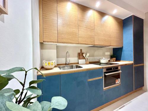 una cocina con armarios azules y fregadero en CAMBARAL AS DE GUIA, en Luarca