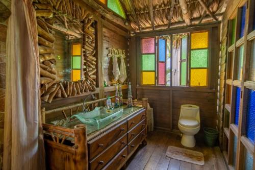 a bathroom with a toilet and stained glass windows at Pacifica in Sipacate