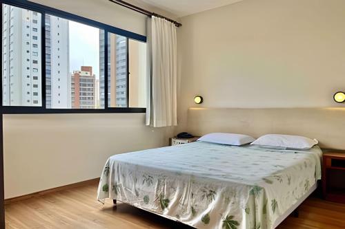 a bedroom with a bed and a large window at Flat SBC · ENB | Ótimo Flat no Centro de SBC para até 4 pp in São Bernardo do Campo