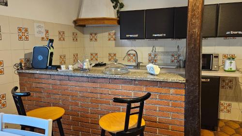 a kitchen with a brick counter and two stools at Adri's House in Monterotondo