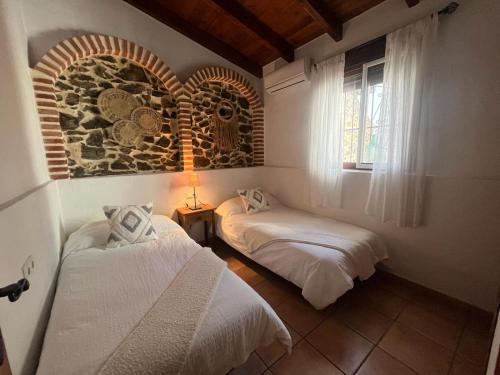 sypialnia z dwoma łóżkami i oknem w obiekcie Casa rural Cortijo El Verdial w mieście Torrox
